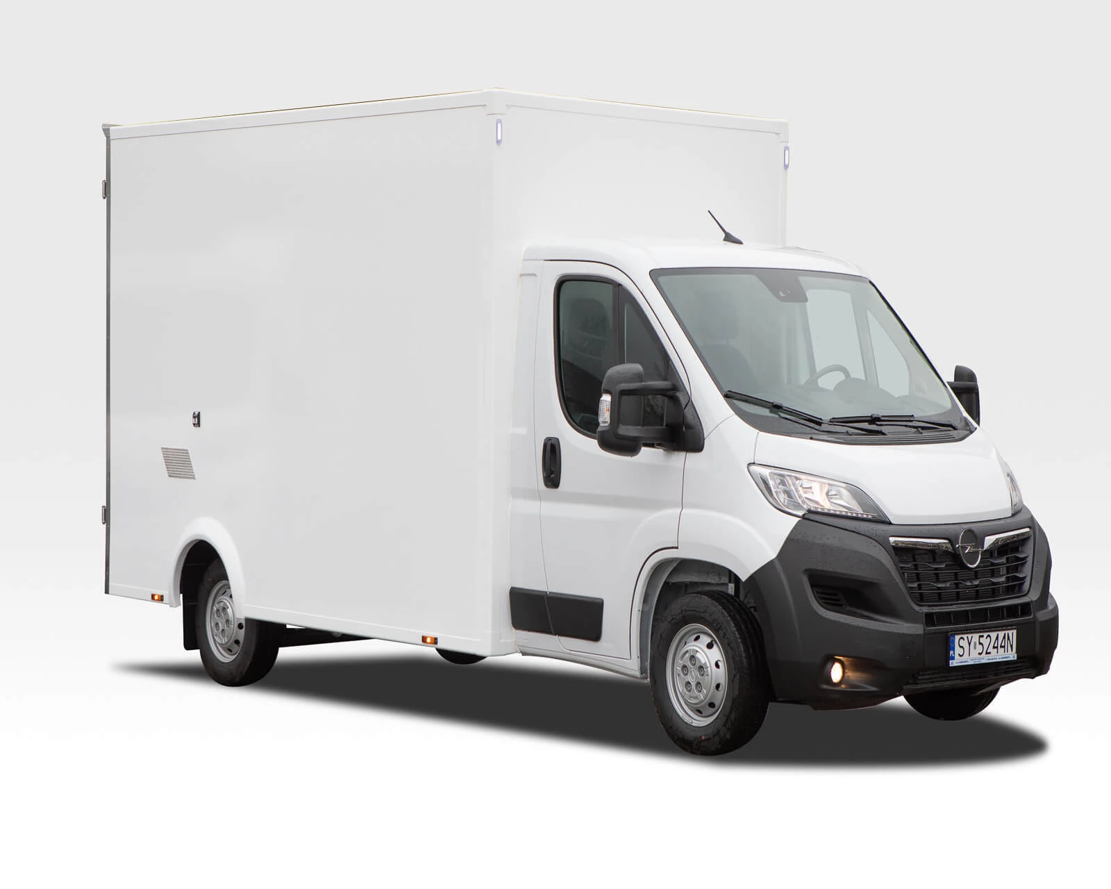 Biała furgonetka dostawcza z dużym, gładkim kontenerem cargo. Widok pod kątem na białym tle.