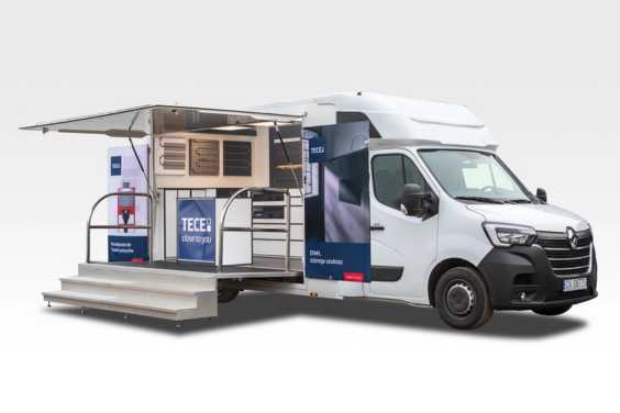 samochod-wystawowy-tece Biały samochód wystawowy marki Renault Master z otwartą boczną ścianą, eksponujący różne produkty instalacyjne i materiały marketingowe TECE. Przed samochodem rozłożone schody i podest.